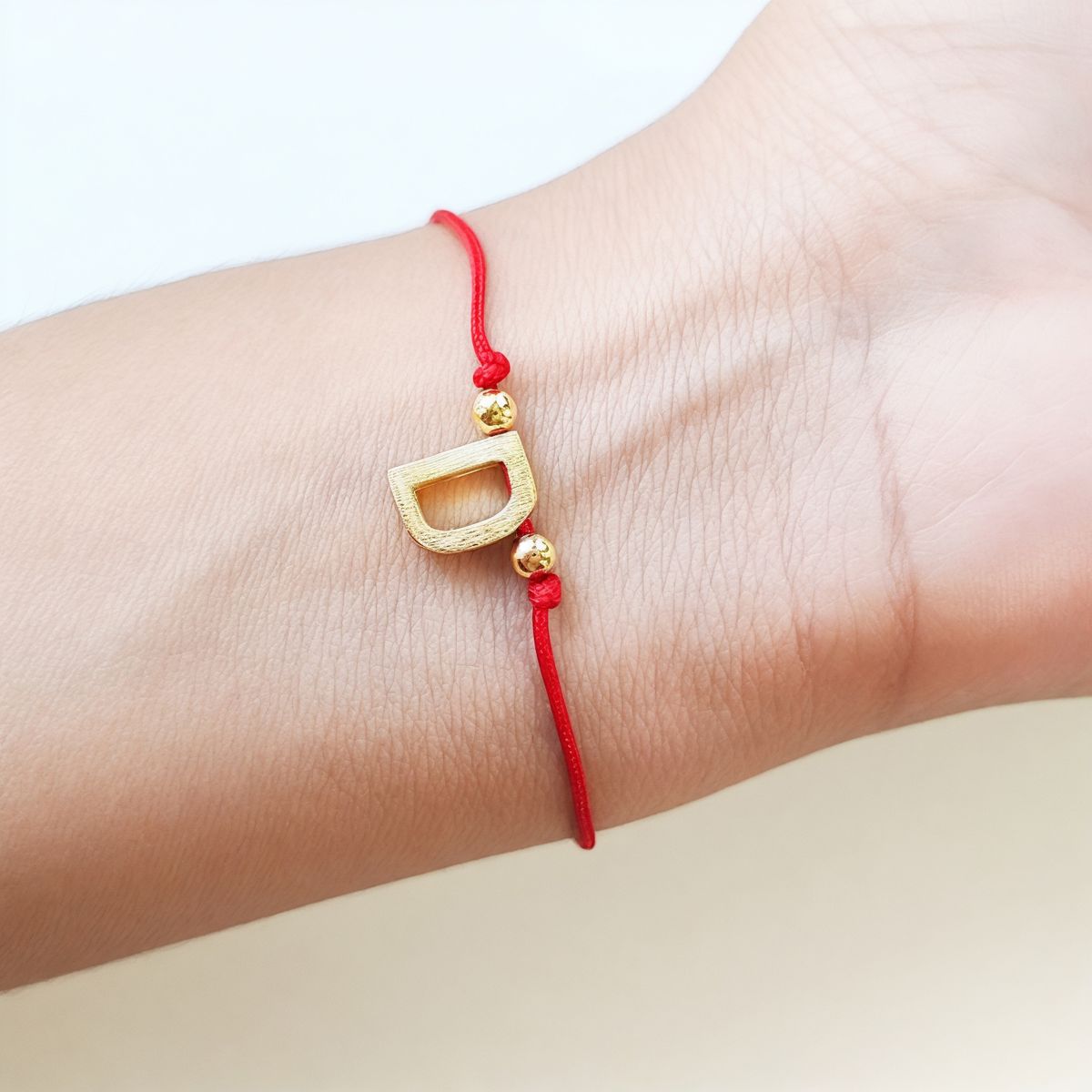 COGGIOLA - Pulsera Letras D Cordón Rojo Enchapado Oro 18K