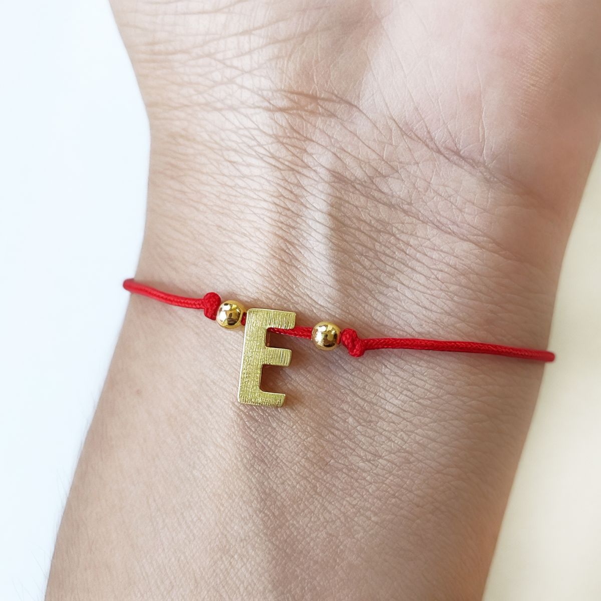 COGGIOLA - Pulsera Letras E Cordón Rojo Enchapado Oro 18K