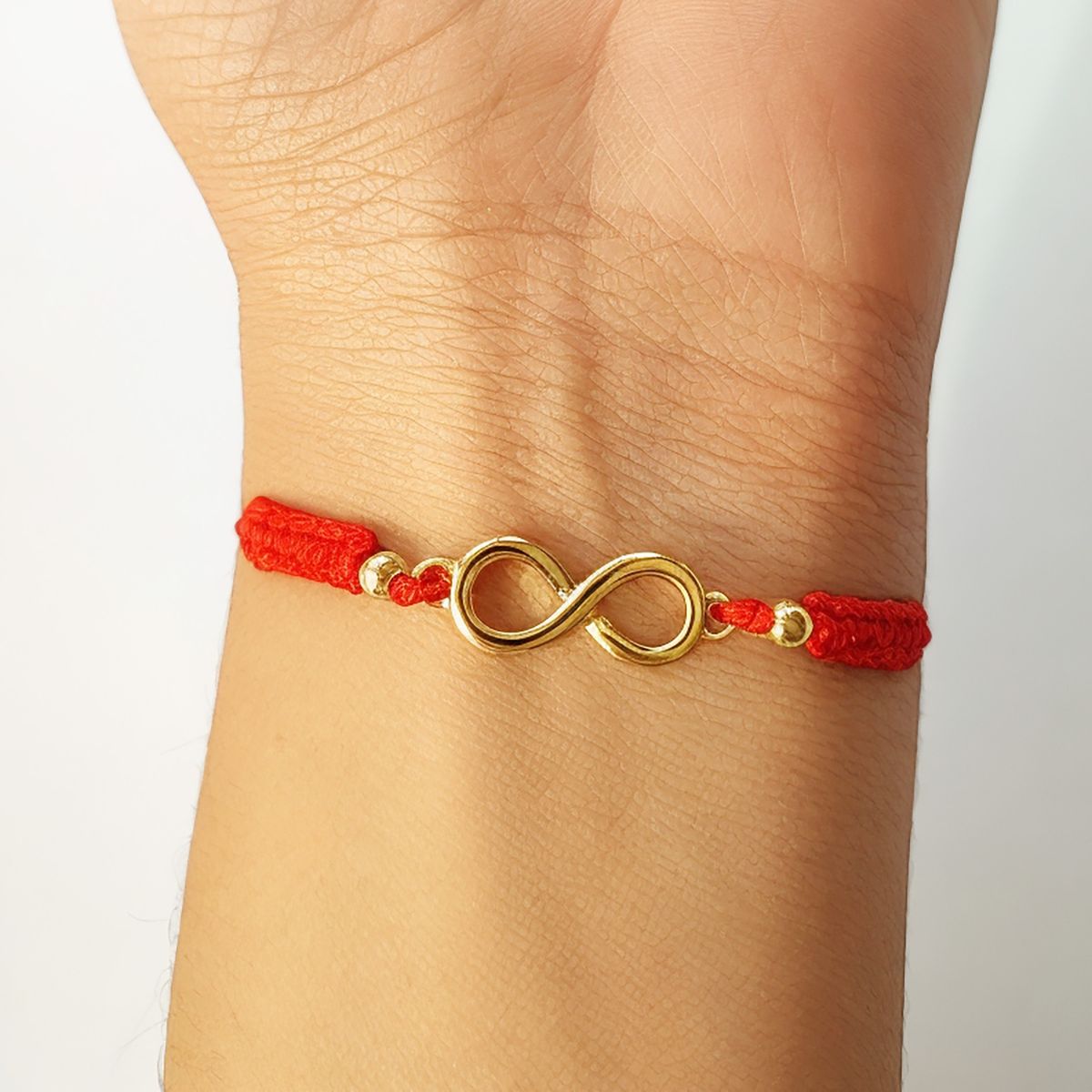 ANDREA COGGIOLA JOYAS - Pulsera Infinito Bolitas Enchapados Oro 18K Cordón Rojo