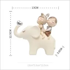 BILBOLA - Pareja de niños sentados en elefante crema