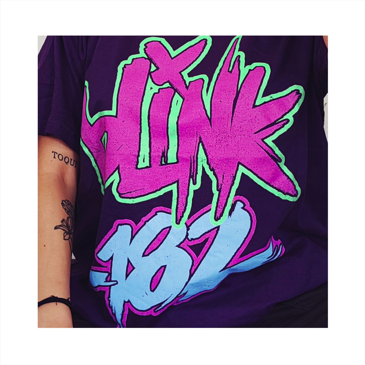 ROCK OFF OFFICIALLY LICENSED PRODUCTS - Polera original unisex de Blink 182 color purpura diseño neon Blink