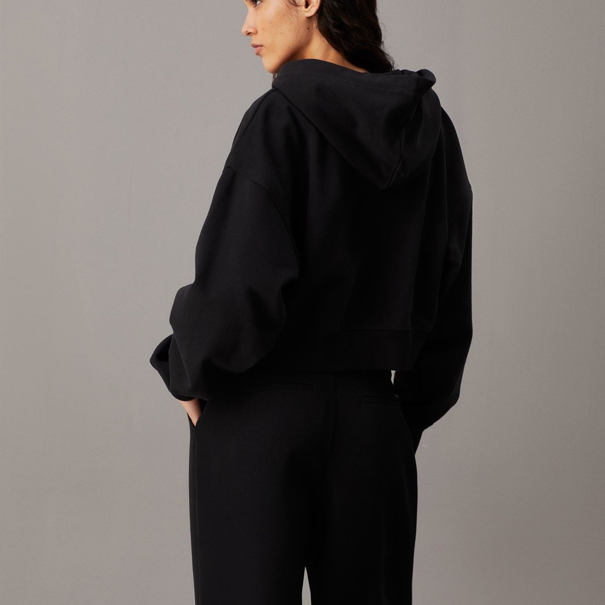 CALVIN KLEIN - Buzo negro cropped con capota, cremallera y logo Calvin Klein