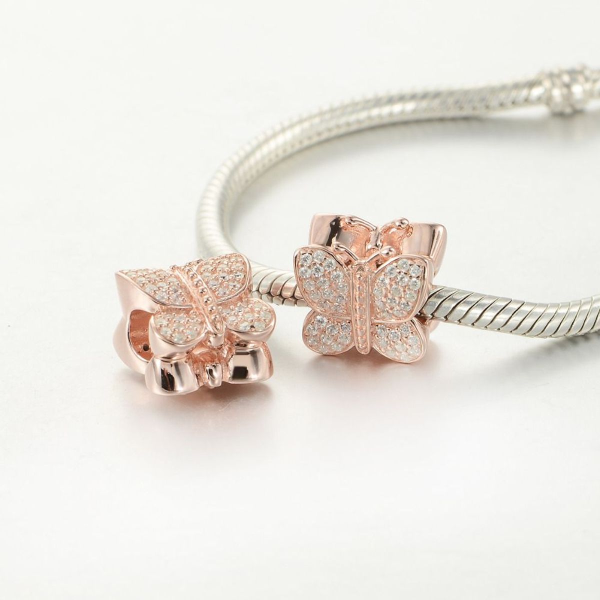 FERNANDA ROMERO JOYAS Y ACCESORIOS - 2 Dijes Charm: 1 Mariposa circones blancos + 1 Barril circones negros