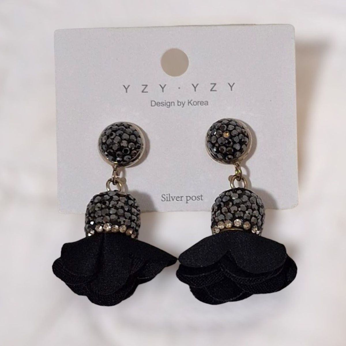 GENERICO - Aretes en diseño flor de tela color negro con piedras de fantasía plateadas