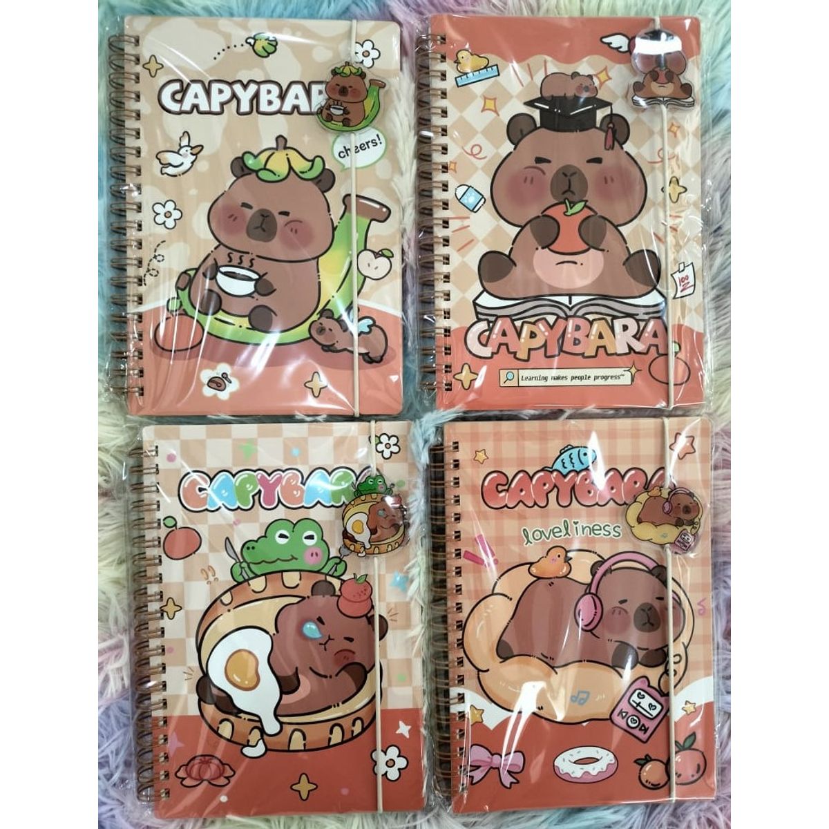 GENERICO - PACKX4 CUADERNOS CAPYBARA A5 CON LIGA Y DIJE CAPIBARA